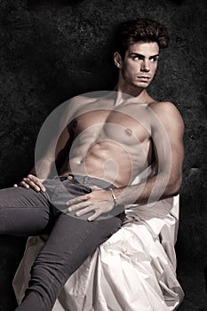 Italian model muscular man sitting. Shirtless portrait