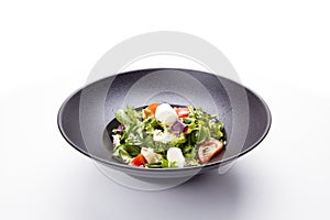 Italian mozzarella cheese and tomato salad with tomatoes and crisp crunchy fried bread cretins, view from above on a black plate