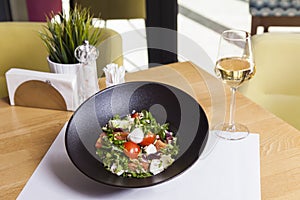 Italian mozzarella cheese and tomato salad with tomatoes and crisp crunchy fried bread cretins, view from above on a black plate