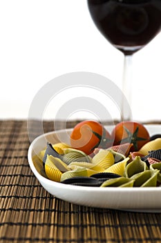 Italian multicolor pasta with wine glass