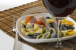 Italian multicolor pasta with wine glass