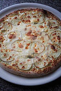 pizza with pear and gargantilla on a white plate photo