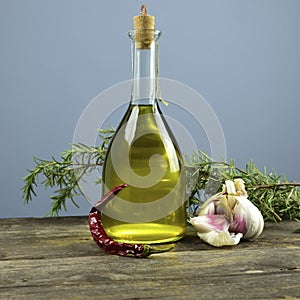 Italian olive oil in bottles with aromatic herbs