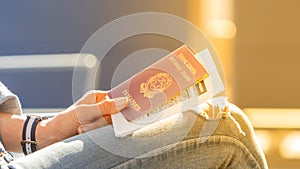 Italian passport and boarding pass in the hands of woman awaiting departure flight in waiting hall