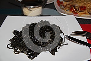 Italian pasta al Nero with seafood and tomatoes. Venice, Italy