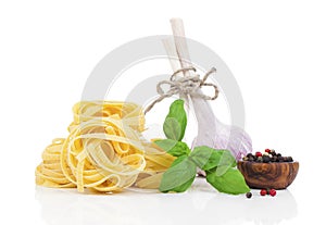Italian pasta fettuccine nest with garlic and fresh basil leaves