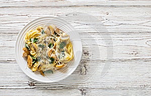 Italian pasta fetuccini with mushrooms, chicken meat, spinach and cream sauce