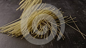 Italian pasta homemade are falling on a dark wooden background. Slow motion, Full HD video, 240fps, 1080p.