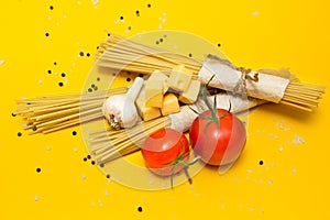 Italian pasta ingredients on a yellow background, top view