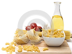 Italian pasta, macaroni quills with cherry tomatoes and olive oil in a glass bottle