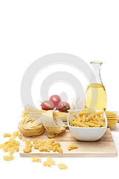 Italian pasta, macaroni quills with cherry tomatoes and olive oil in a glass bottle