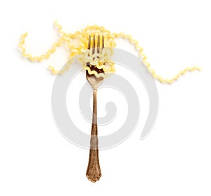 Italian pasta. An overhead photo of a vintage style fork with long fusilli on a white background