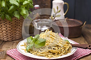 Italian pasta with pesto sauce and fresh basil. A delicious homemade dinner. Photo in a rustic style. Copy space