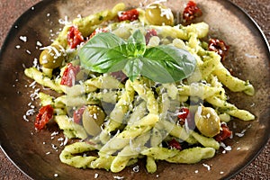 Italian pasta with pesto sauce tomato olive and cheese photo