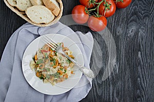 Italian pasta in a sauce with shrimps on a plate, top view. Dark wooden background. Space for text