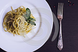 Italian pasta spaghetti with homemade pesto sauce and basil leaf