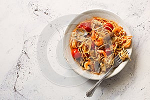 Italian pasta with tomato sauce, scallops and shrimps on gray stone background