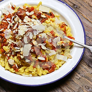 Italian pasta with tomato sauce, smoked pancetta, roasted almond