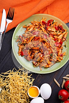 Italian pasta with tomatos and herbs on dark wooden table. flat lay