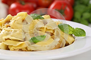 Italian Pasta Tortellini noodles meal with tomatoes and basil on