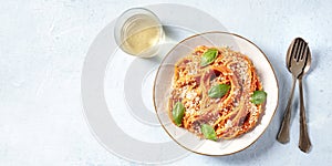 Italian pasta and wine panorama. Spaghetti with tomato sauce, cheese and basil, shot from the top