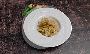 italian pasta with zucchini flowers pine nuts and cherry tomatoes, pennette wheat pasta italian food