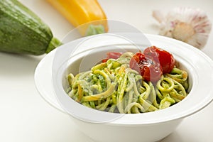 italian Pasta with zucchini noodles and Avocado Sauce and garlic in white plate. Healthy food concept.