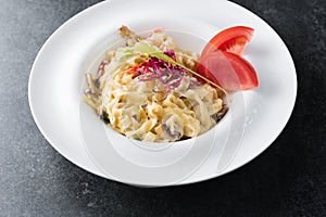 Italian paste of carbonaria with mushrooms with cream sauce on a white plate