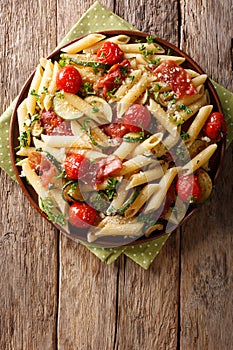 Italian penne pasta with ham prosciutto, tomato, zucchini and pa