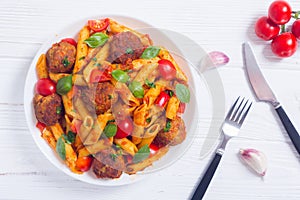 Italian penne pasta with meatballs and tomatoes