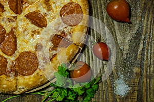 Italian Pepperoni pizza with salami on dark wooden background. Italian traditional food. A textured background. Copy paste place