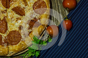Italian Pepperoni pizza with salami on dark wooden background. Italian traditional food. A textured background. Copy paste place