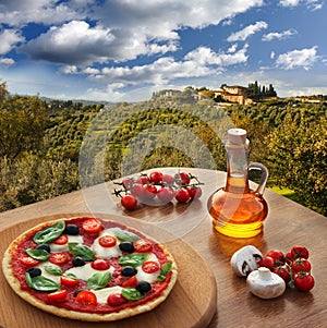 Italian pizza in Chianti against olive trees and villa in Tuscany, Italy