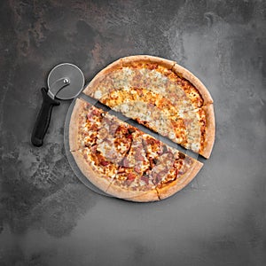 Italian pizza cut in half with cutter on the grey background. Top view and square flat lay photo