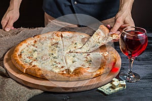 Italian pizza 4 four cheese on the Board with pizza cutter and wine