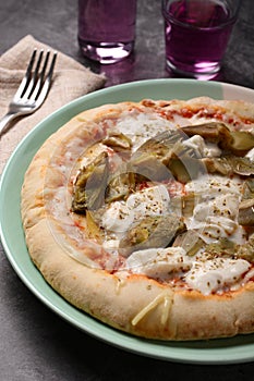 Italian pizza with mozzarella, tomato and artichokes on gray background