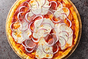 Italian Pizza pugliese topped with tomato sauce, melted cheese and lots of red onion close-up on a wooden board. Horizontal top