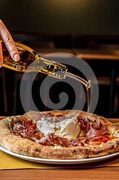 Italian pizza with real, cold-pressed olive oil, burrata, ham from Parma