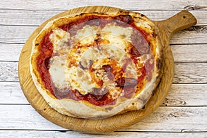 Italian pizza with salami and lots of cheese and thin wheat flour dough served