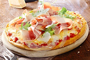 Italian pizza topped with prosciutto photo