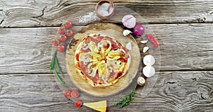 Italian pizza on wooden table with vegetables and spices