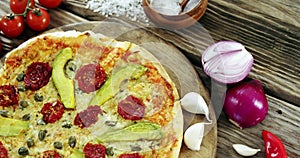 Italian pizza on wooden table with vegetables and spices