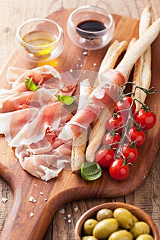 Italian prosciutto ham grissini bread sticks tomato olive oil