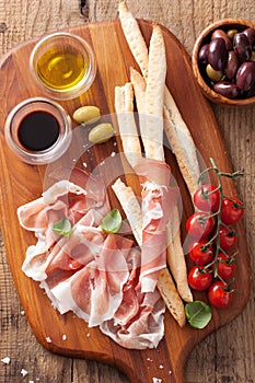 Italian prosciutto ham grissini bread sticks tomato olive oil