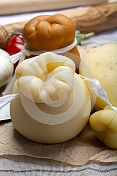 Italian provolone or provola caciocavallo hard and smoked cheeses in teardrop form served on old paper close up