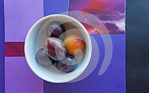 Italian prune plums on vivid geometric background