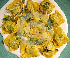 italian ravioli filled with cheese and spinach smothered in a creamy sauce on an plate