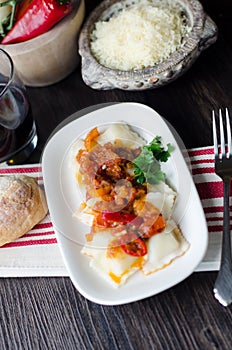 Italian ravioli in red hot sauce photo