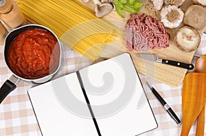 Italian recipe book or cookbook with ingredients for spaghetti bolognese, copy space