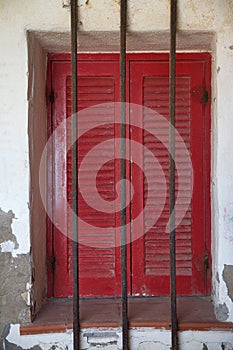 Italian Red Shutters on Stucco with Metal Bars